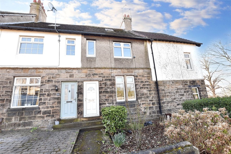 a 3 bedroom stone mid-terraced house with front garden, 2 stories and an attic room window