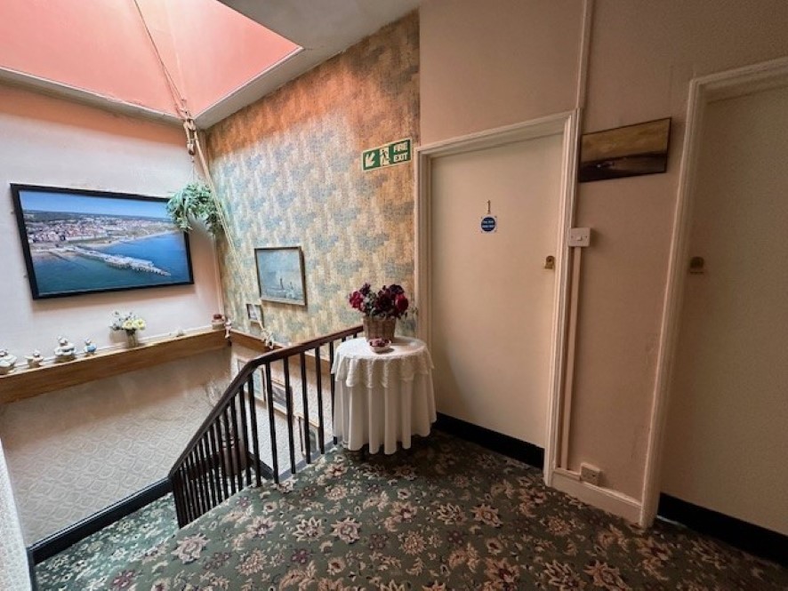 The stairwell flooded with natural light from the ceiling window