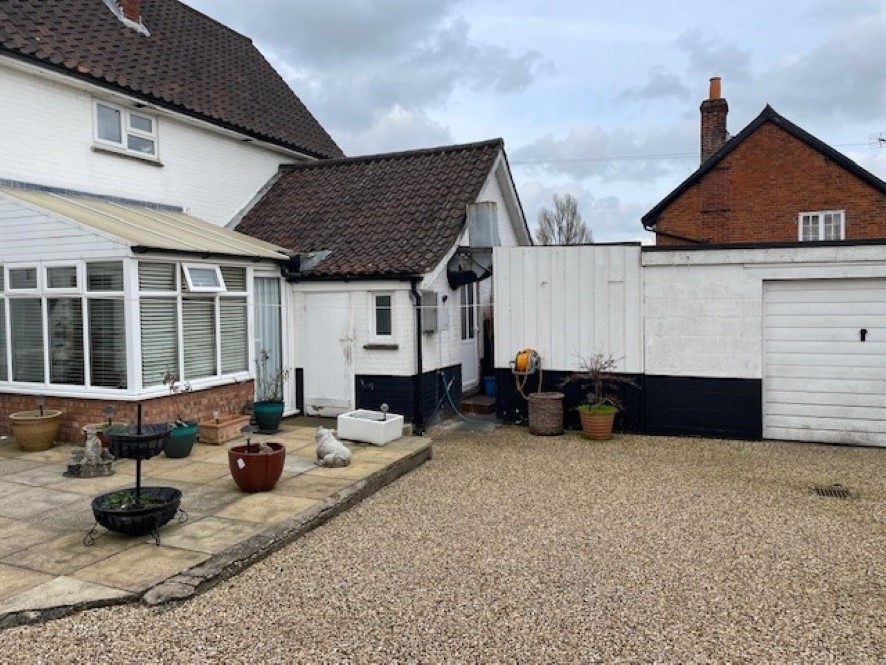 Rear of the property with a courtyard and outbuildings